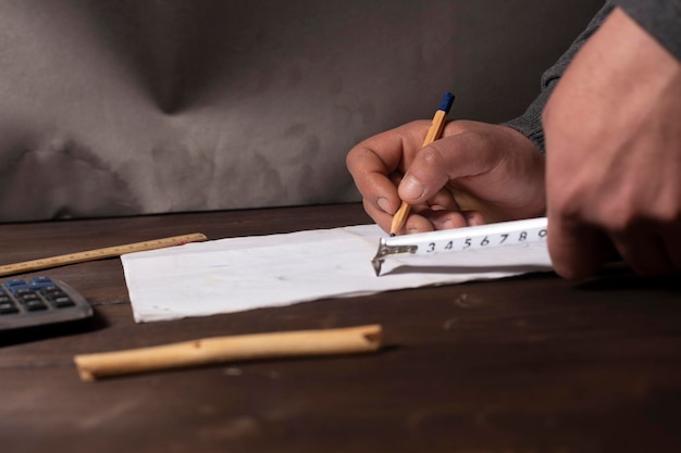 A close-up of a hand filling out an unemployment benefits application form, with a pen and calculator nearby, emphasizing the process of applying for benefits.