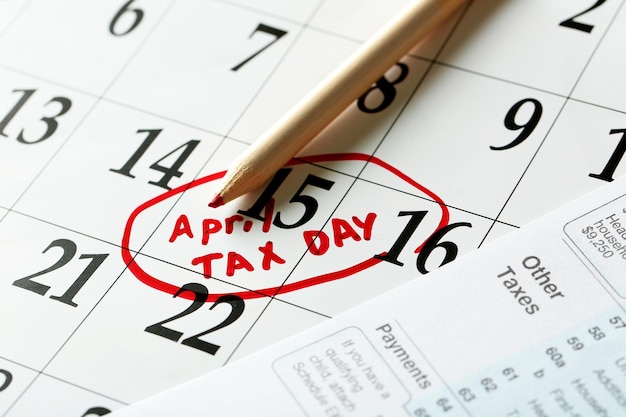 A close-up shot of a calendar with April 15th circled, symbolizing the tax deadline. A pen rests on the calendar, suggesting planning and preparation.